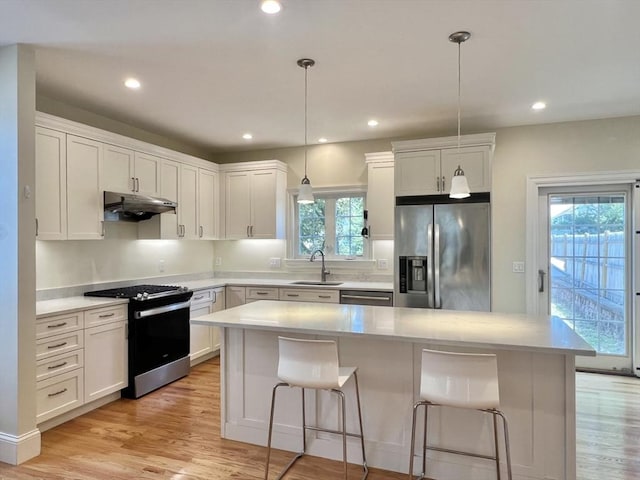 141 Pearl St Unit 141, Newton, MA 02458 - kitchen featuring stainless steel appliances, under cabinet range hood, a kitchen bar, light countertops, and recessed lighting