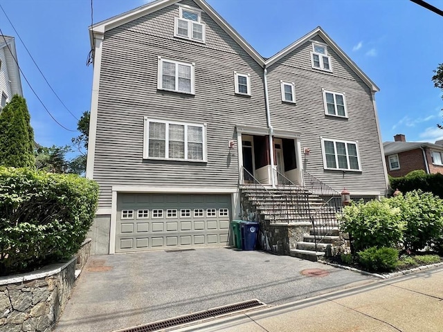 141 Pearl St Unit 141, Newton, MA 02458 - view of front facade featuring a garage and asphalt driveway