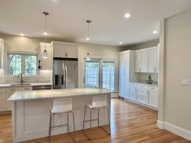 141 Pearl St Unit 141, Newton, MA 02458 - kitchen featuring appliances with stainless steel finishes, light countertops, healthy amount of natural light, light wood finished floors, and recessed lighting