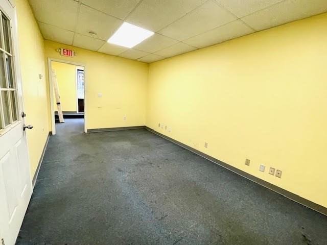 carpeted empty room with a paneled ceiling