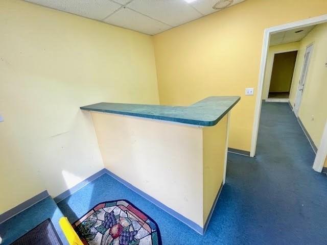 bar with dark colored carpet and a drop ceiling