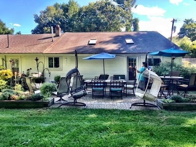 back of property featuring a patio area and a lawn