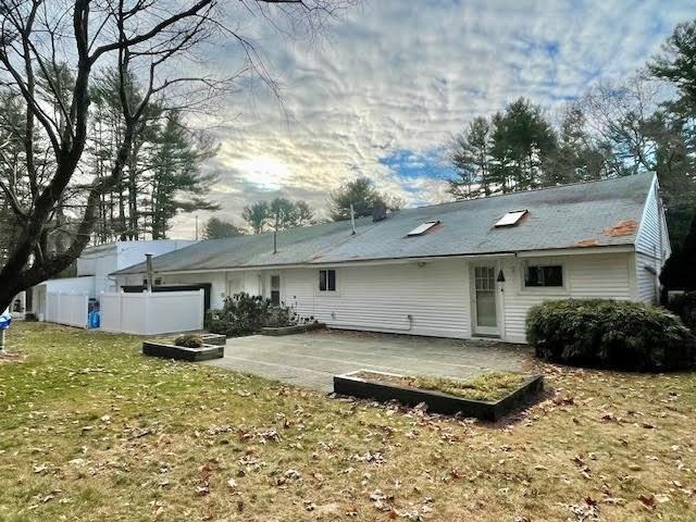 back of house featuring a lawn and a patio area