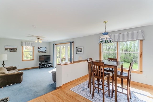 dining space with ceiling fan, baseboards, visible vents, and light wood-style flooring