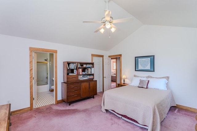 bedroom featuring baseboards, ensuite bathroom, vaulted ceiling, and light carpet