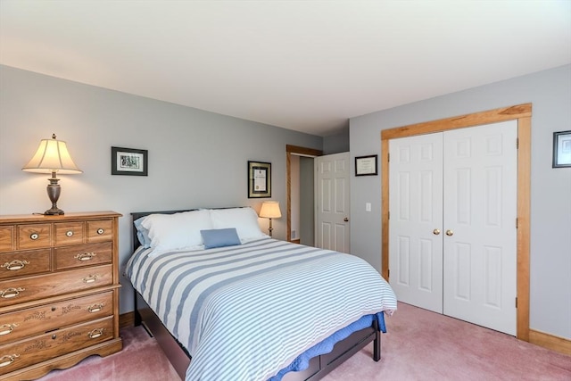 bedroom featuring baseboards, light carpet, and a closet