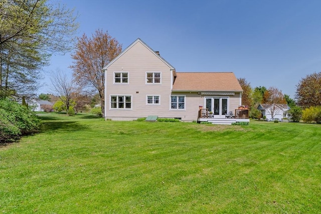 rear view of property featuring a lawn and a wooden deck