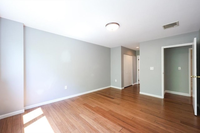 spare room with wood finished floors and baseboards