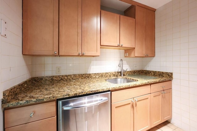 kitchen featuring dishwasher, a sink, tile walls, light stone counters, and tasteful backsplash