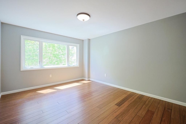 unfurnished room with wood finished floors and baseboards