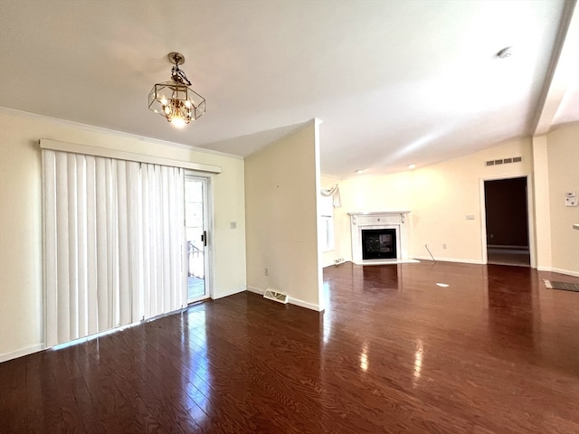 unfurnished living room with dark wood-type flooring, lofted ceiling, and an inviting chandelier