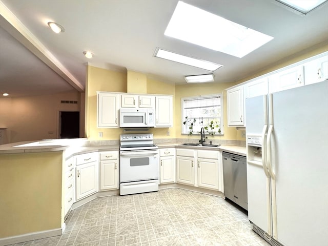 kitchen with vaulted ceiling with skylight, white cabinetry, sink, and white appliances