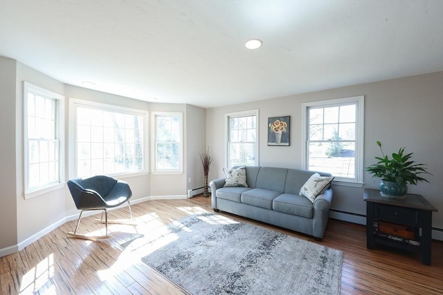 living room featuring a baseboard radiator, wood-type flooring, and baseboards