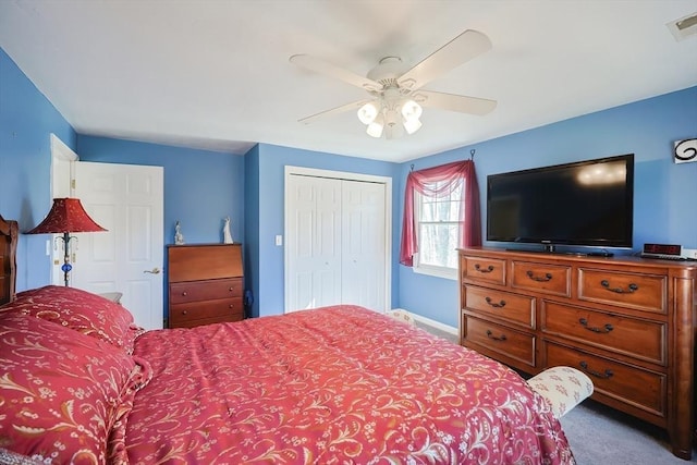 carpeted bedroom featuring baseboards, visible vents, a closet, and ceiling fan