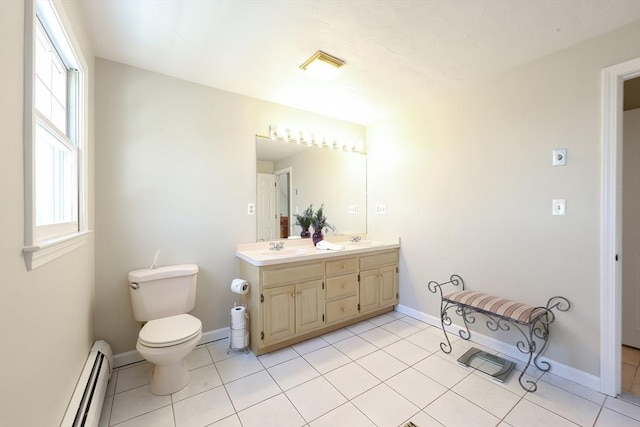 bathroom with a sink, toilet, double vanity, and tile patterned flooring