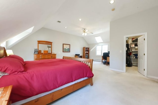 carpeted bedroom featuring a spacious closet, visible vents, ceiling fan, vaulted ceiling with skylight, and recessed lighting