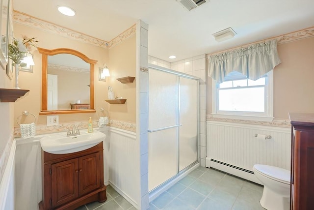 bathroom with visible vents, a shower stall, baseboard heating, wainscoting, and vanity