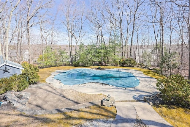 view of swimming pool featuring a covered pool and a patio