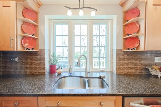 kitchen with open shelves, dark stone counters, and a sink