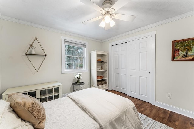 bedroom with a closet, crown molding, baseboards, and wood finished floors