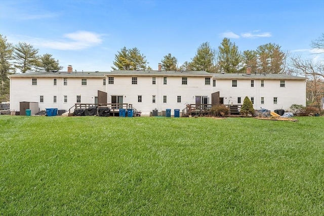 back of property featuring central AC unit, a lawn, and a deck