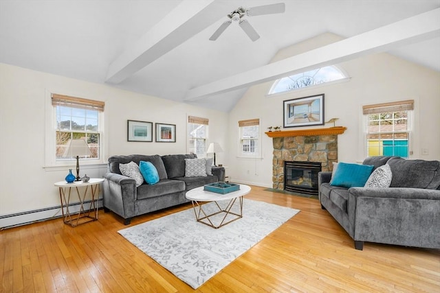 living room featuring light wood-type flooring, ceiling fan, vaulted ceiling with beams, a stone fireplace, and plenty of natural light