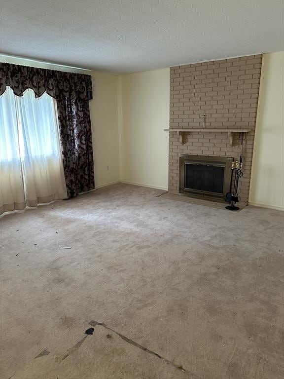 55 Alexander Ave, Dracut, MA 01826 - unfurnished living room featuring a brick fireplace, carpet floors, and a textured ceiling
