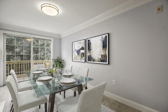 dining space featuring crown molding and baseboards