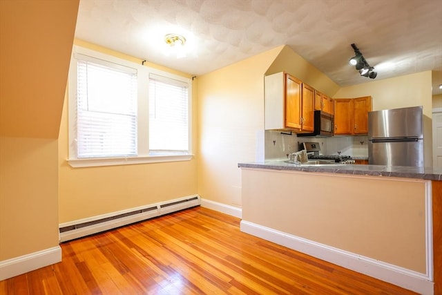2A Hazel St Unit 3, Salem, MA 01970 - kitchen featuring stainless steel appliances, baseboard heating, baseboards, light wood finished floors, and brown cabinets