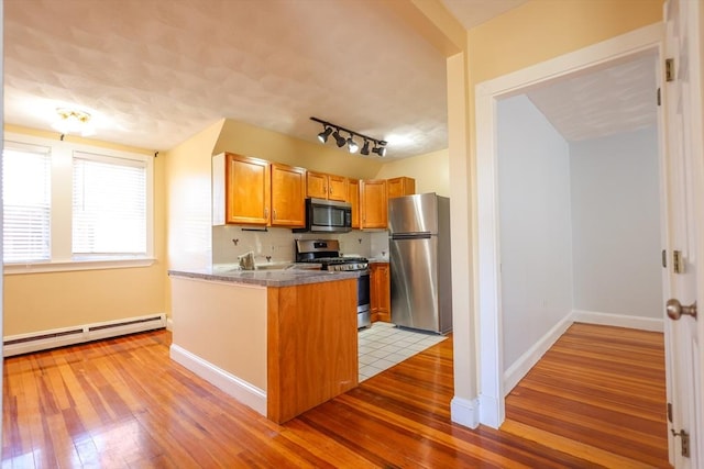 2A Hazel St Unit 3, Salem, MA 01970 - kitchen featuring appliances with stainless steel finishes, baseboard heating, light wood-type flooring, and a peninsula