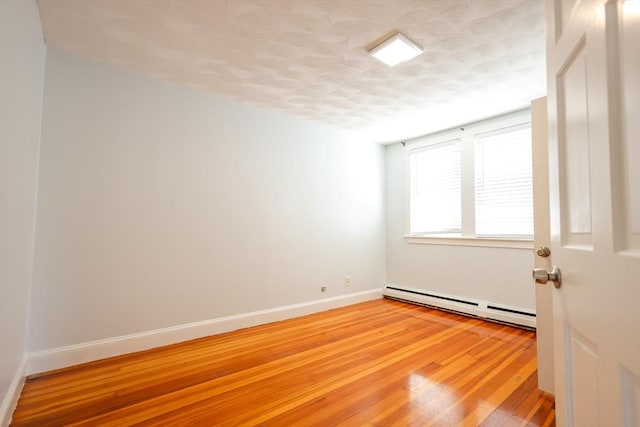 2A Hazel St Unit 3, Salem, MA 01970 - unfurnished room featuring a baseboard heating unit, a textured ceiling, light wood finished floors, and baseboards
