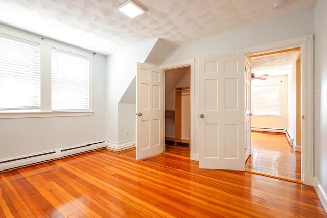 2A Hazel St Unit 3, Salem, MA 01970 - unfurnished bedroom with light wood-style flooring, a baseboard radiator, a closet, and a walk in closet