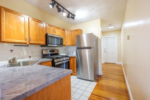 2A Hazel St Unit 3, Salem, MA 01970 - kitchen featuring appliances with stainless steel finishes, a sink, tasteful backsplash, light wood-style flooring, and baseboards