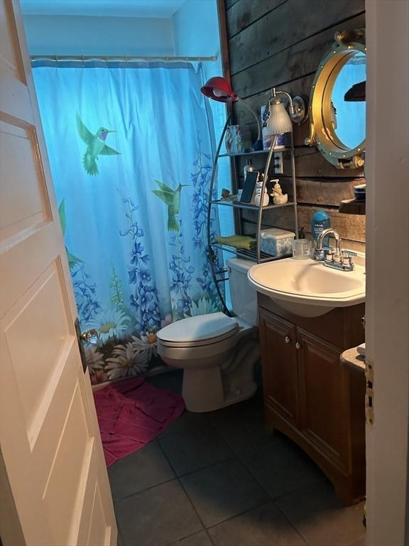 bathroom featuring tile patterned flooring, vanity, toilet, and a shower with curtain