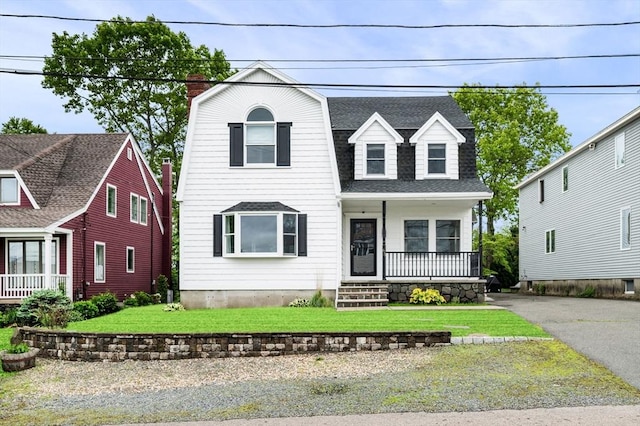 65 Prospect St, Swampscott, MA 01907 - view of front of house with a porch, a chimney, a gambrel roof, a shingled roof, and a front lawn