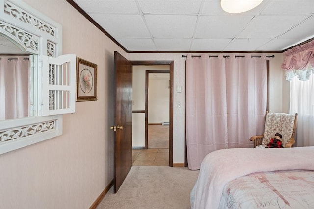 bedroom featuring crown molding, light colored carpet, and a drop ceiling