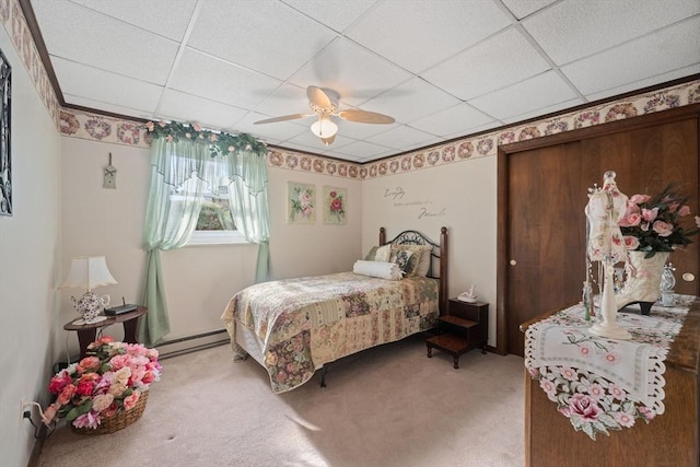 carpeted bedroom with a drop ceiling, ceiling fan, and baseboard heating