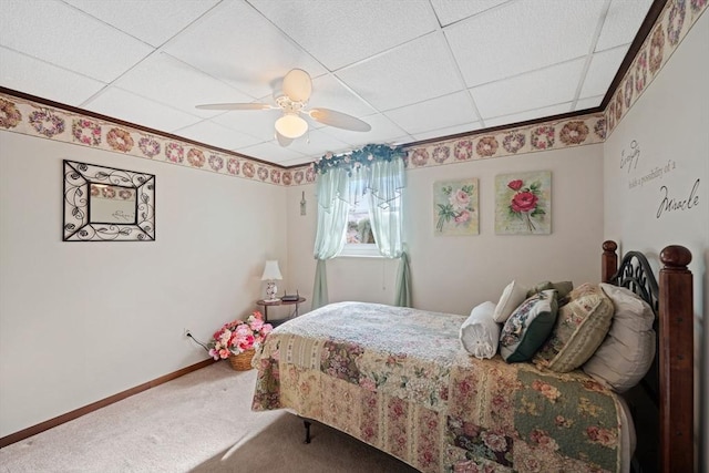 carpeted bedroom featuring a drop ceiling and ceiling fan