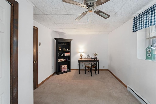 office space featuring a baseboard radiator, a paneled ceiling, light colored carpet, and ceiling fan