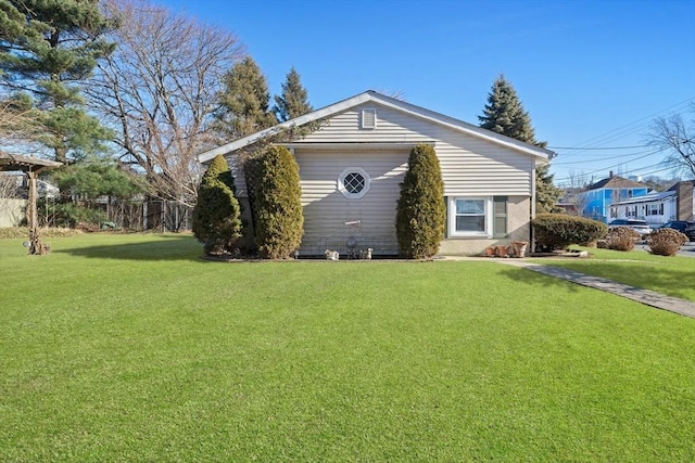 view of side of home featuring a garage, an outdoor structure, and a yard