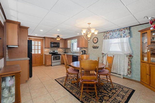 tiled dining room with a healthy amount of sunlight, a paneled ceiling, and baseboard heating