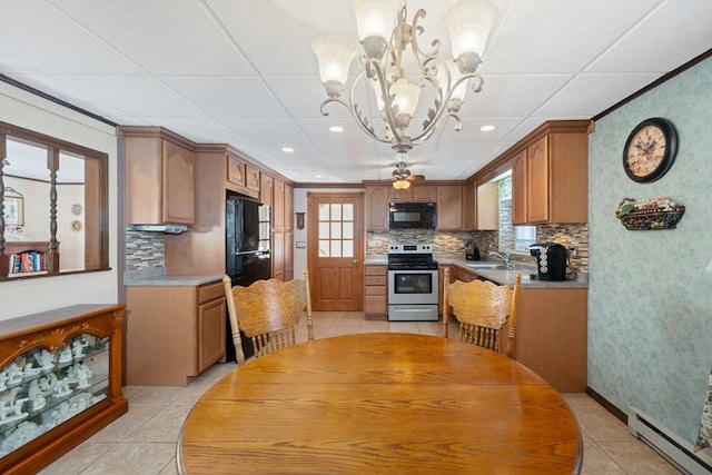 kitchen with sink, black appliances, hanging light fixtures, a wealth of natural light, and a baseboard heating unit