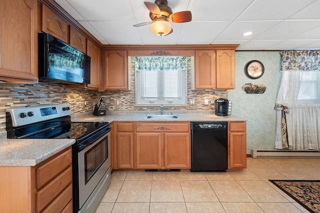 kitchen with a baseboard radiator, sink, backsplash, light tile patterned floors, and black appliances