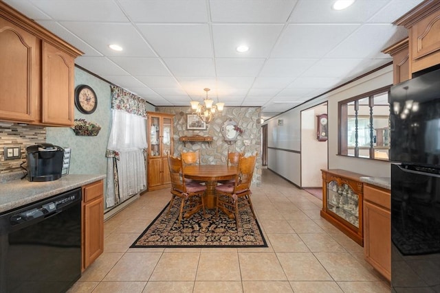 dining room with a paneled ceiling, a healthy amount of sunlight, a chandelier, and light tile patterned floors