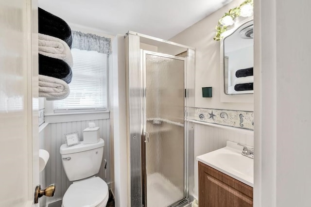 bathroom with an enclosed shower, wood walls, toilet, and vanity