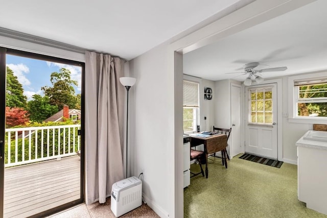 doorway featuring ceiling fan and carpet floors