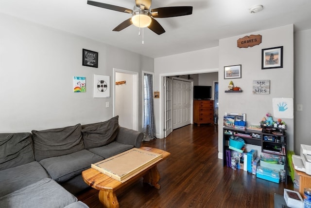 living room featuring dark wood-type flooring and ceiling fan