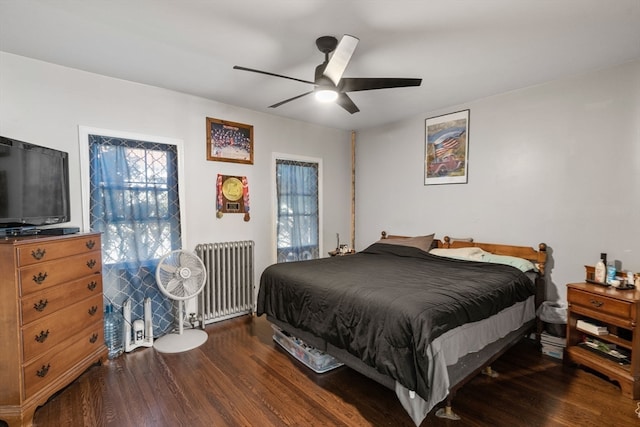 bedroom featuring dark wood-type flooring, ceiling fan, radiator, and multiple windows