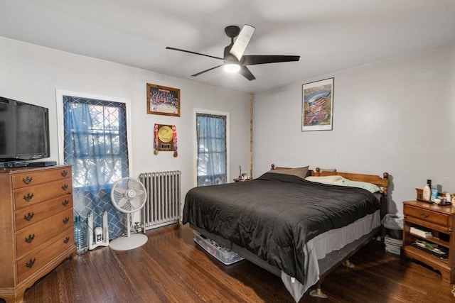 bedroom with a ceiling fan, radiator heating unit, and wood finished floors