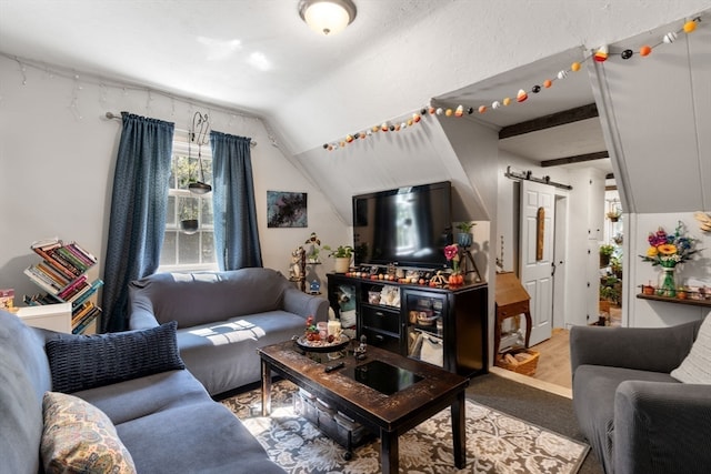 living room with a barn door and vaulted ceiling